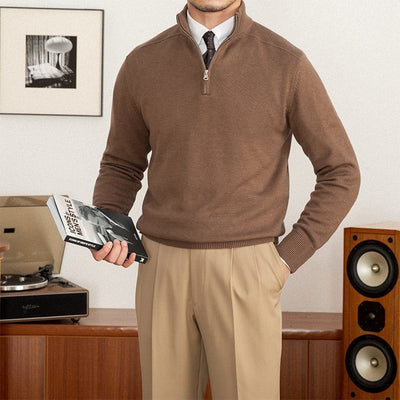 Quarter-zip wool pullover sweater paired with dress pants and a tie indoors