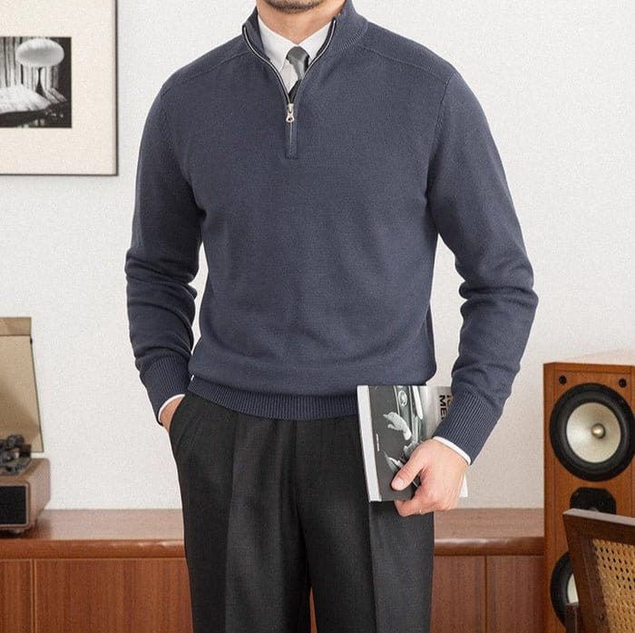 Quarter-zip wool pullover sweater paired with dress pants and a tie indoors